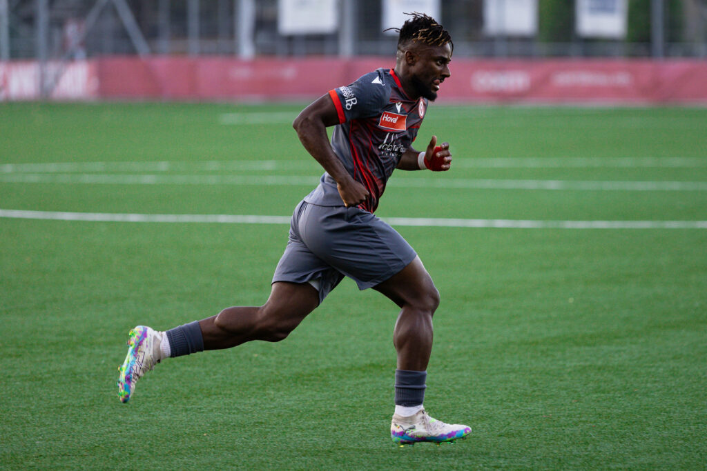 Muskulöser Fussballer sprintet über das Feld