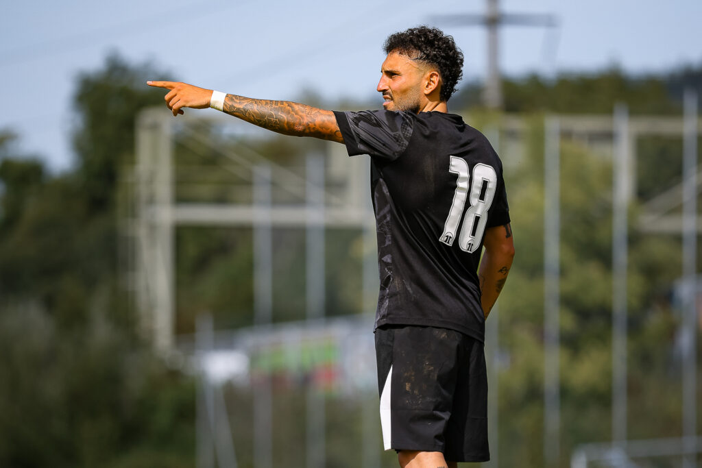 Fussballer zeigt in eine Richtung